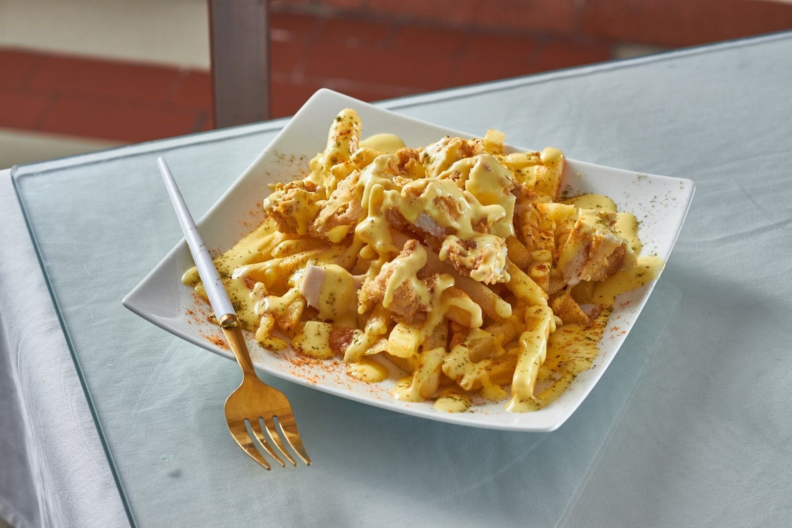 French fries with chicken in cheese sauce