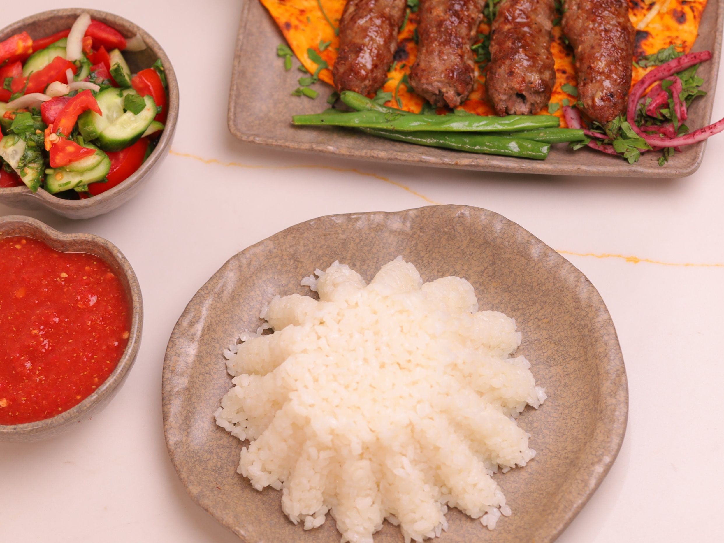 Kofta with white rice, green salad, and daqoos salad