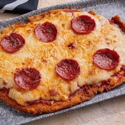 Pizza-style schnitzel with a side dish.