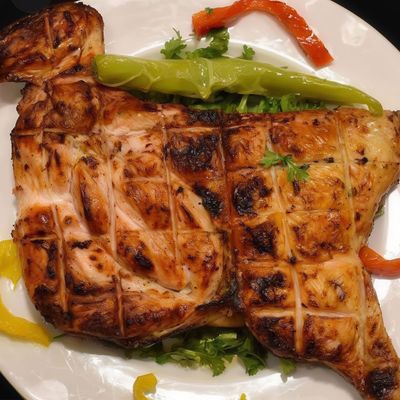Half grilled chicken on charcoal