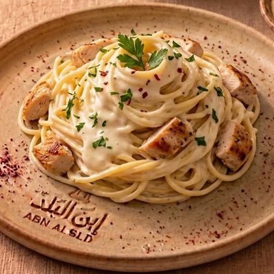 Spaghetti pasta with white sauce and chicken breast pieces