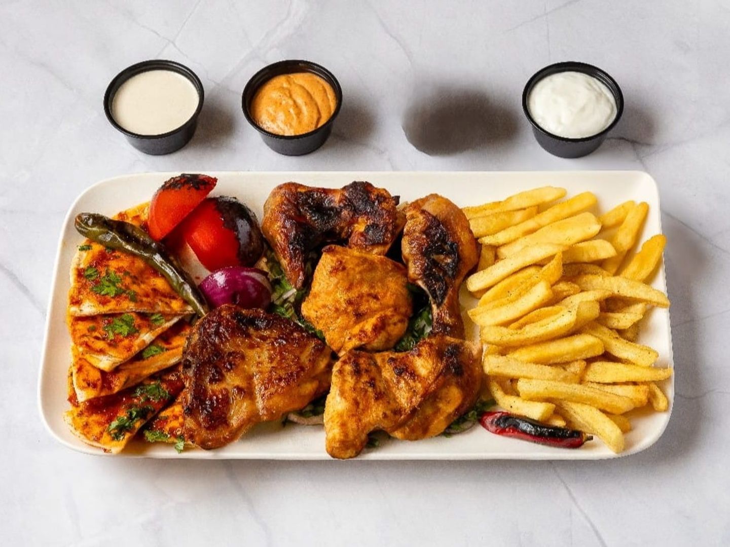 Half A Chicken Grilled On Charcoal With Potatoes