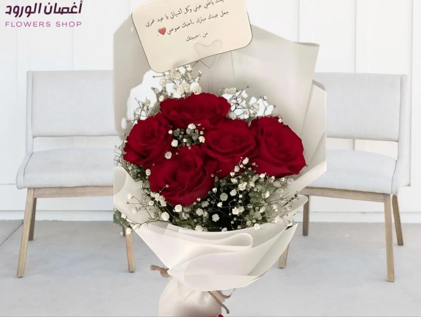 A Bouquet Of Five Red Roses And Baby's Breath With White Wrapping