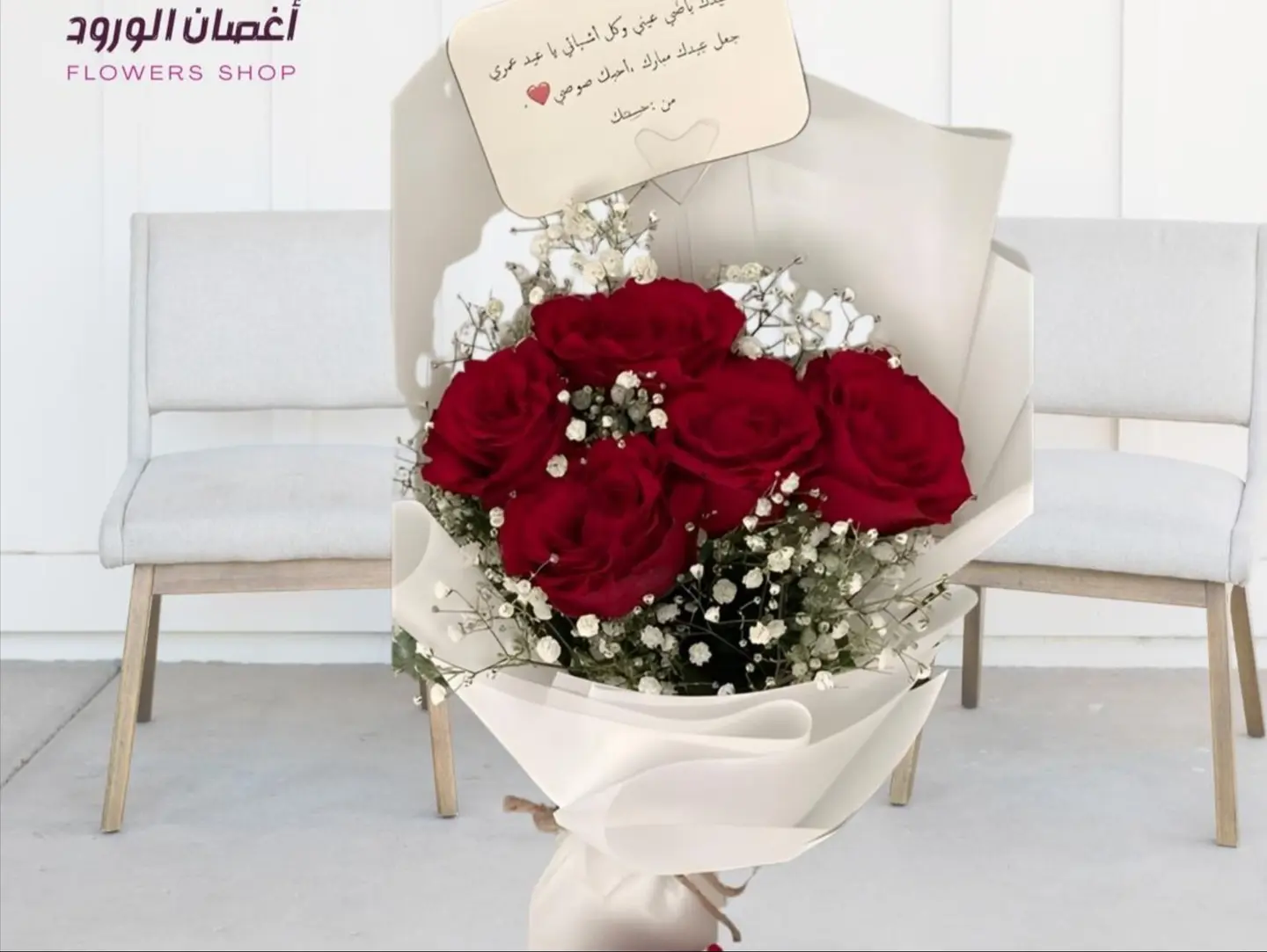 A Bouquet Of Five Red Roses And Baby's Breath With White Wrapping