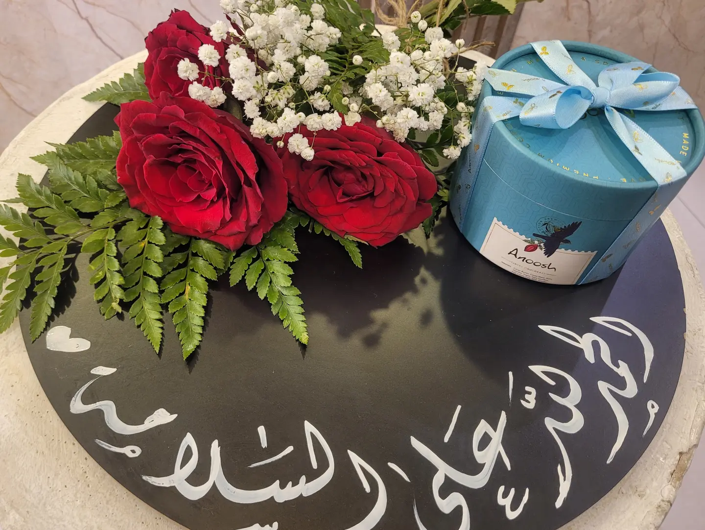 A Plaque Reading Thank God For Your Safe Return Accompanied By Flowers And Anoush Sweets