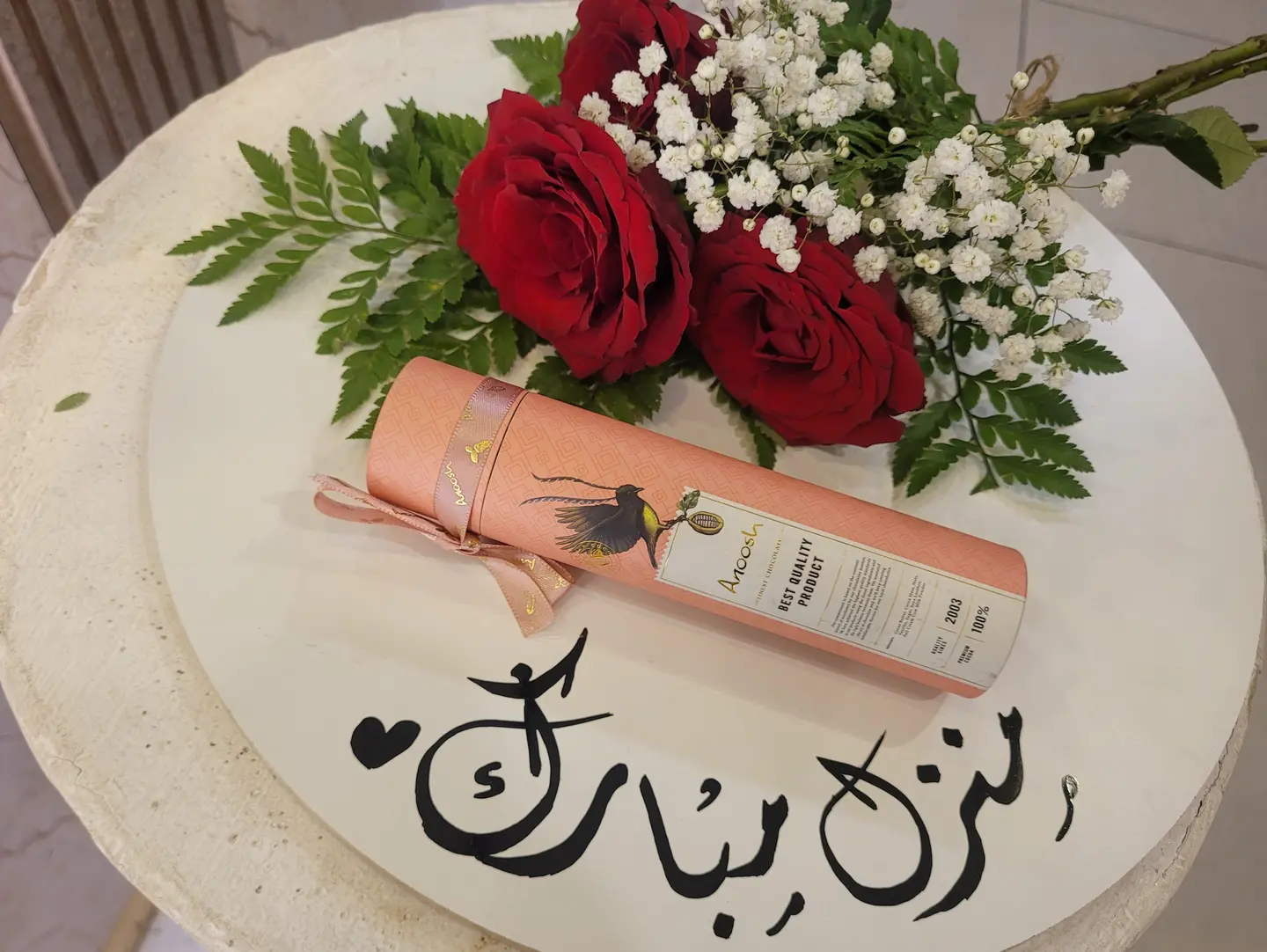 A Plaque Inscribed With Blessed Home Accompanied By Anoush Sweets And Damask Roses