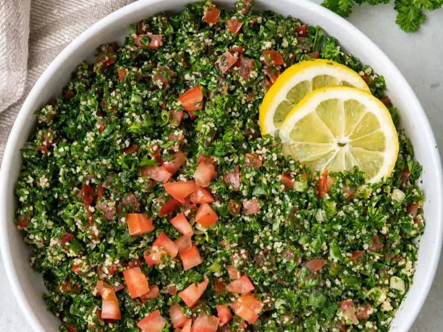 التبولة كوب صغير (250 مل) مع بضع شرائح من الليمون والطماطم