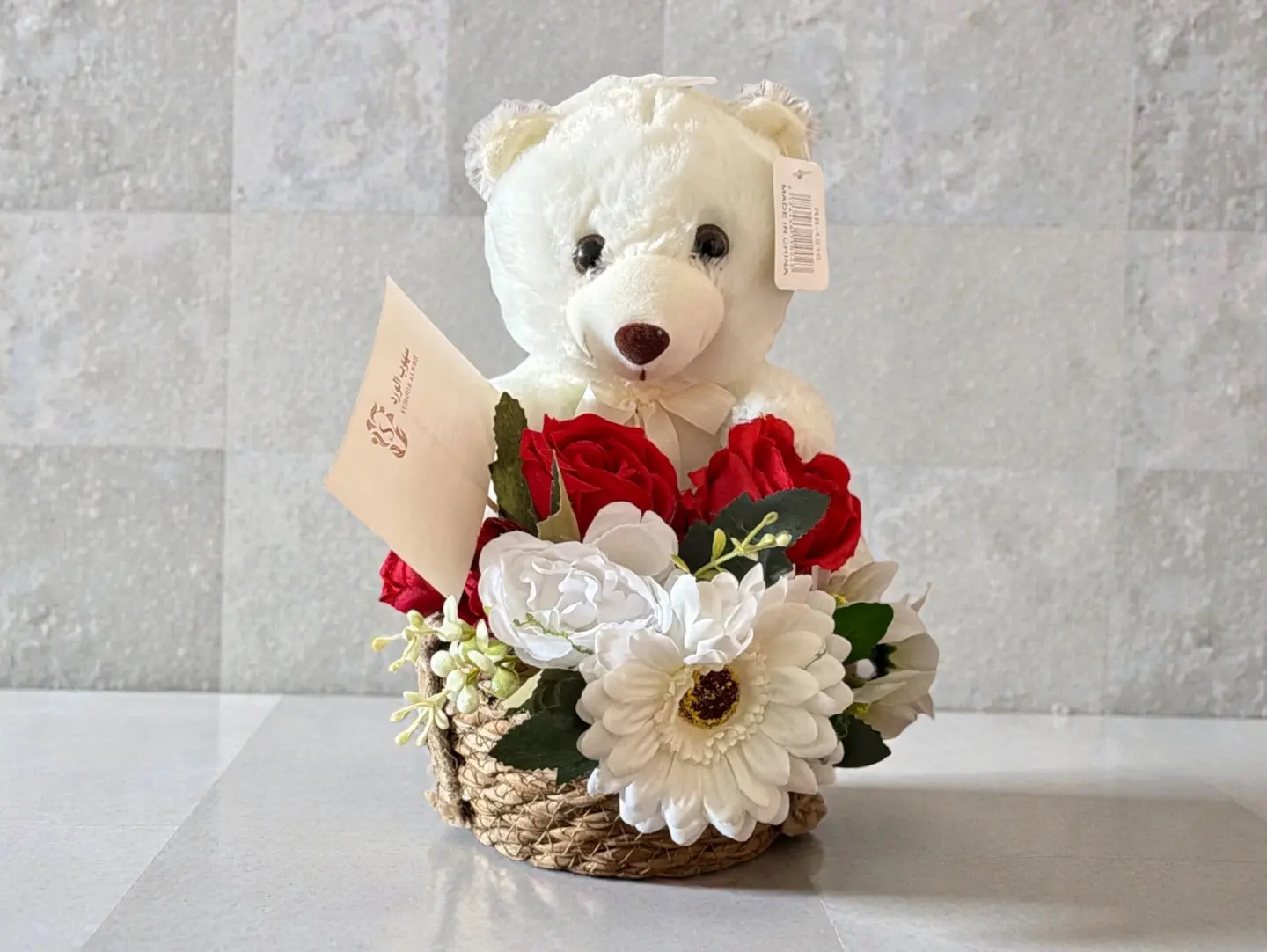 A Teddy Bear And A Small Bouquet Of Artificial Roses
