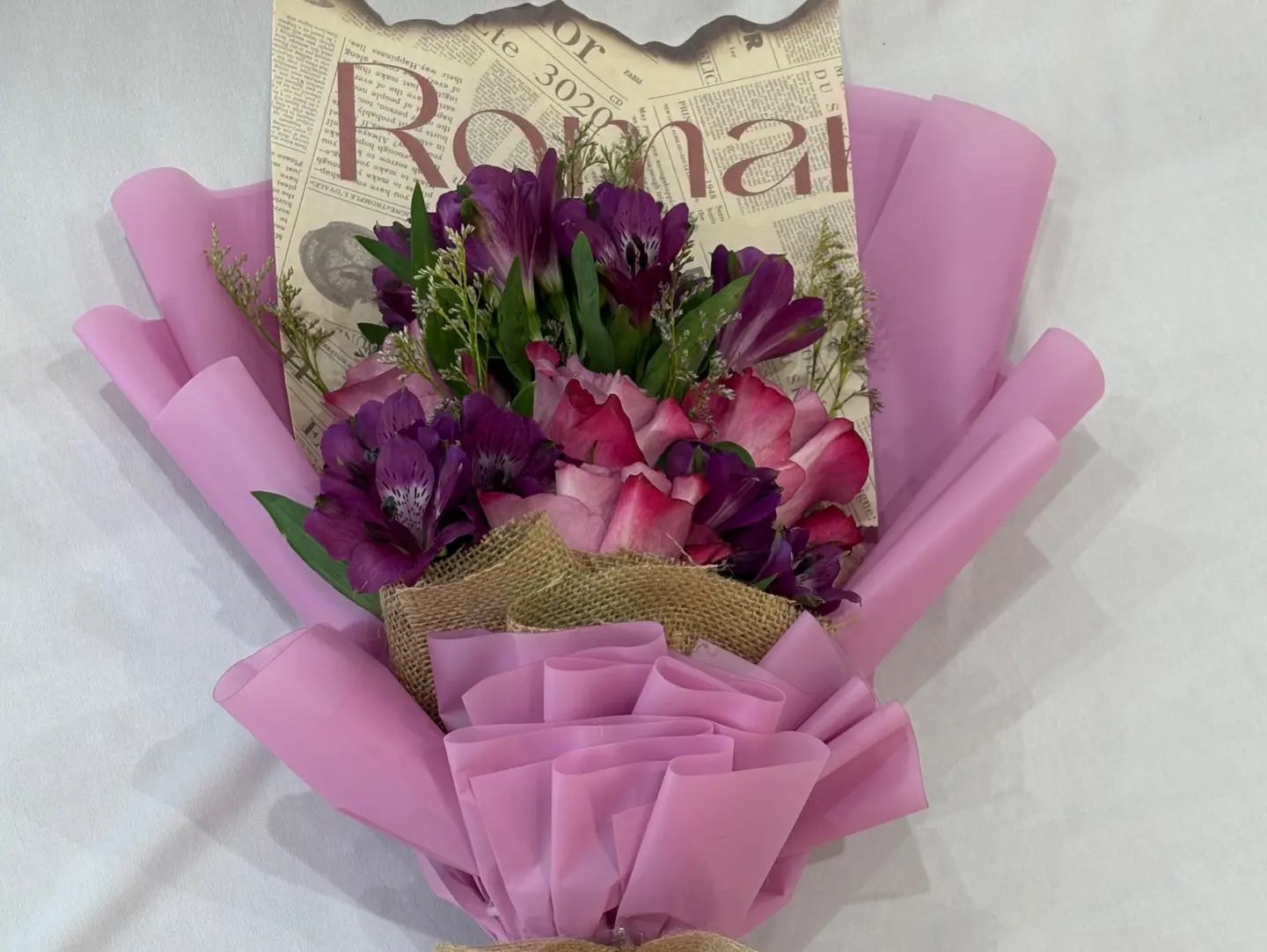 A Bouquet Of Natural Roses, Wrapped In Newspaper And Mauve.