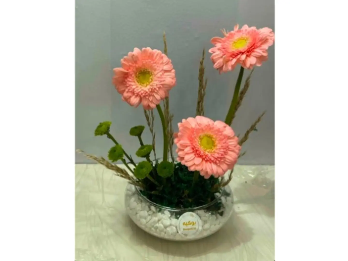 Clear Or White Vase With Gerbera Daisies In Your Choice Of Colors.