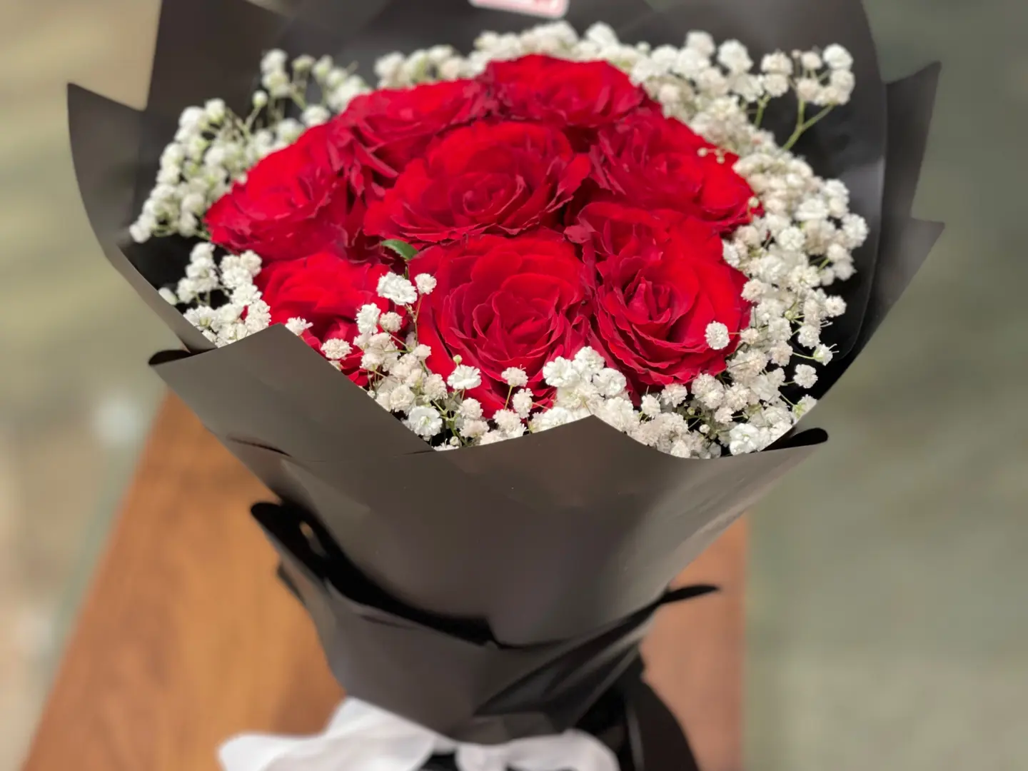 Red Rose Adorned With White Accessories And Black Packaging
