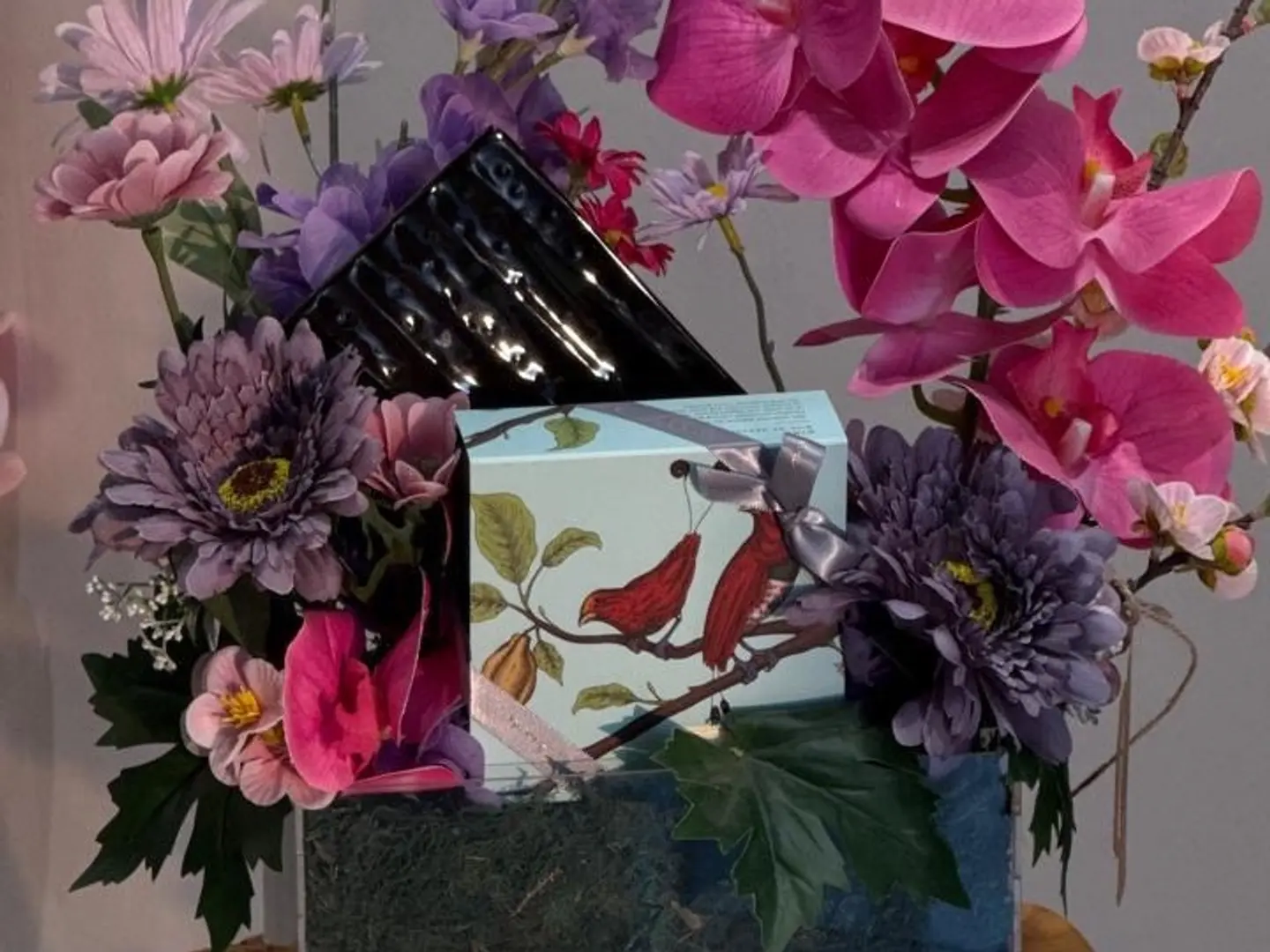 Pink And Purple Artificial Flower Arrangement With Acrylic Base, Anoush Chocolate, And A Black Plate