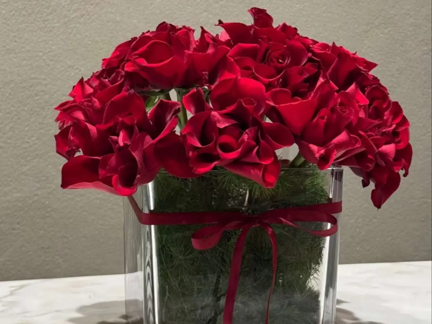 Red Roses In A Square Vase With A Red Ribbon