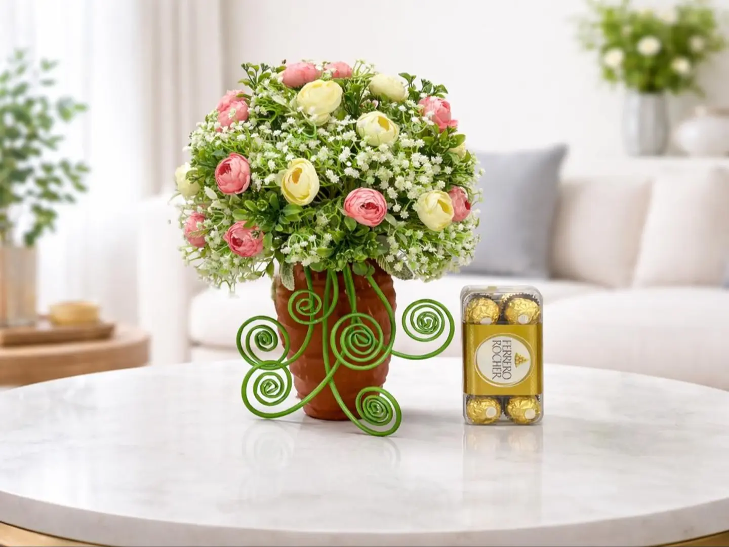 علبة هدايا فاخرة من فيريرو روشيه باللونين الأزرق الداكن والذهبي، مزينة بزهرة الفاوانيا الوردية.