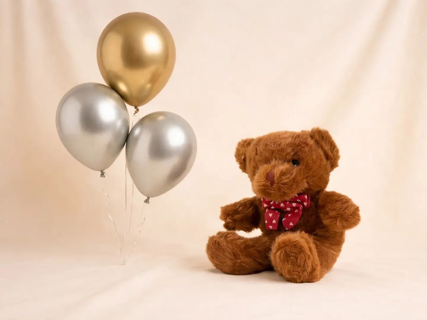 دمية دب بنية اللون مع بالون فضي وذهبي