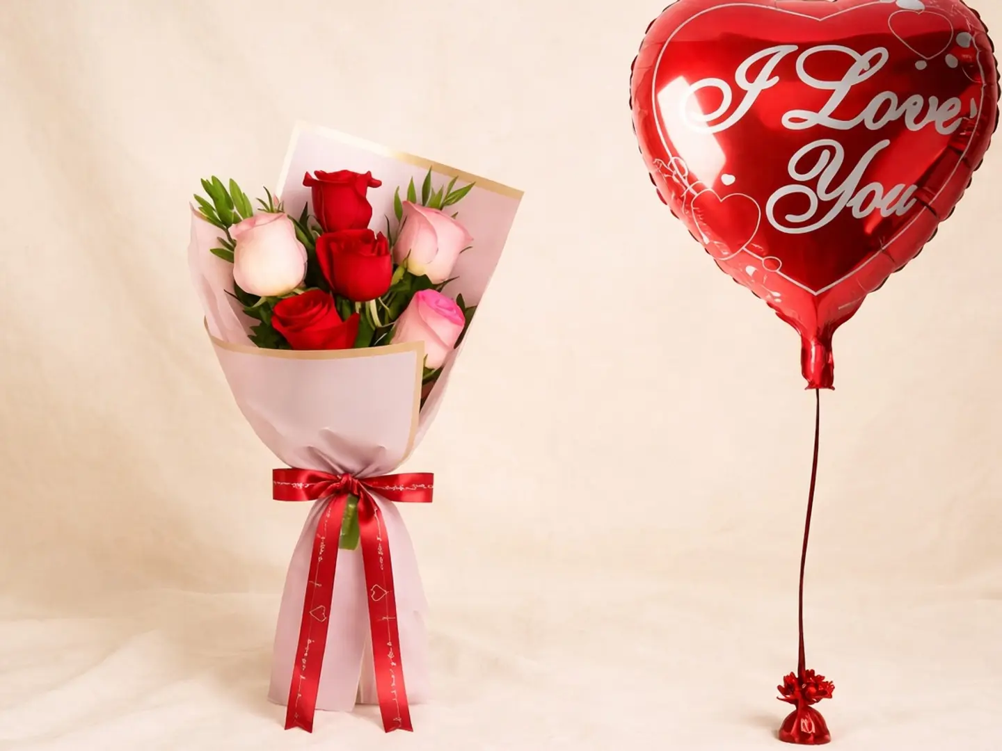 باقة زهور حمراء ووردية مع بالون هيليوم مكتوب عليه أحبك