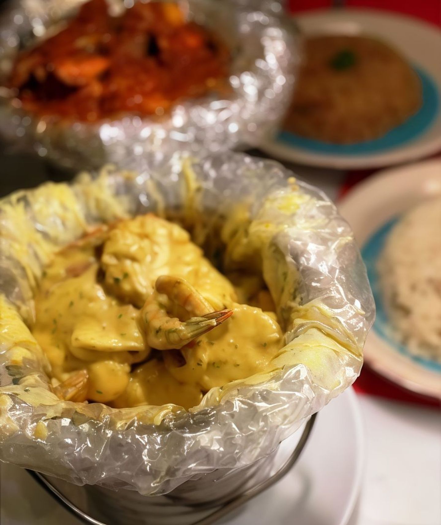 A Bucket Of Shrimp With Spicy Red Sauce