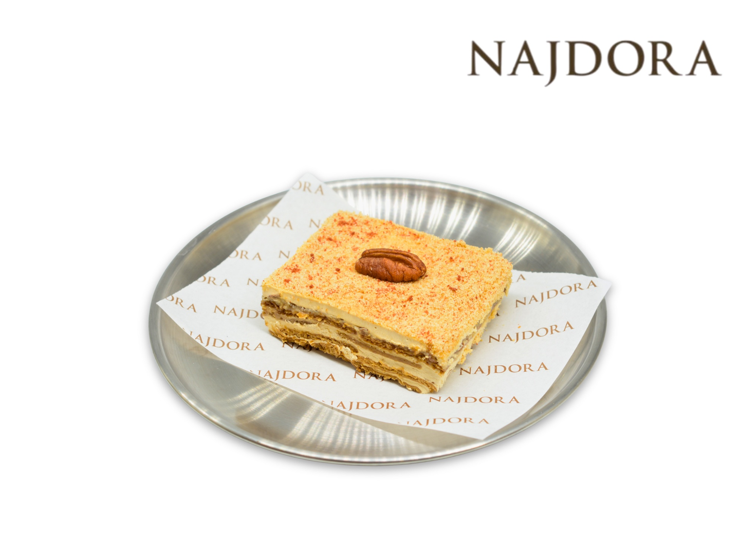 Soft And Fluffy White Cake Topped With A Rich Creamy Layer, Garnished With Toasted Pecan Nuts For A Perfectly Balanced Flavor