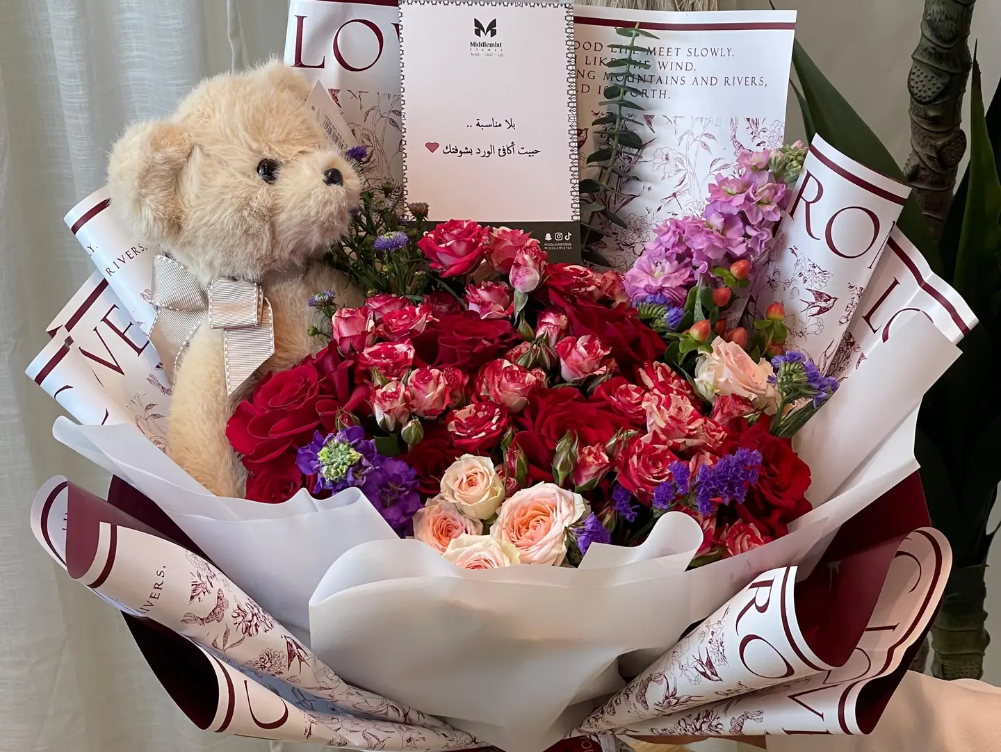 An Elegant Bouquet Of Red Roses With A Teddy Bear