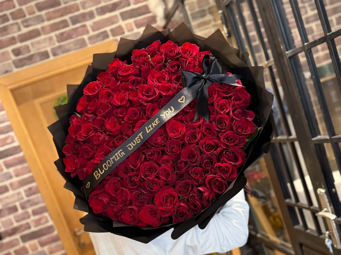 باقة روز أحمر كبيرة ١٠٠ حبة مع عبارة