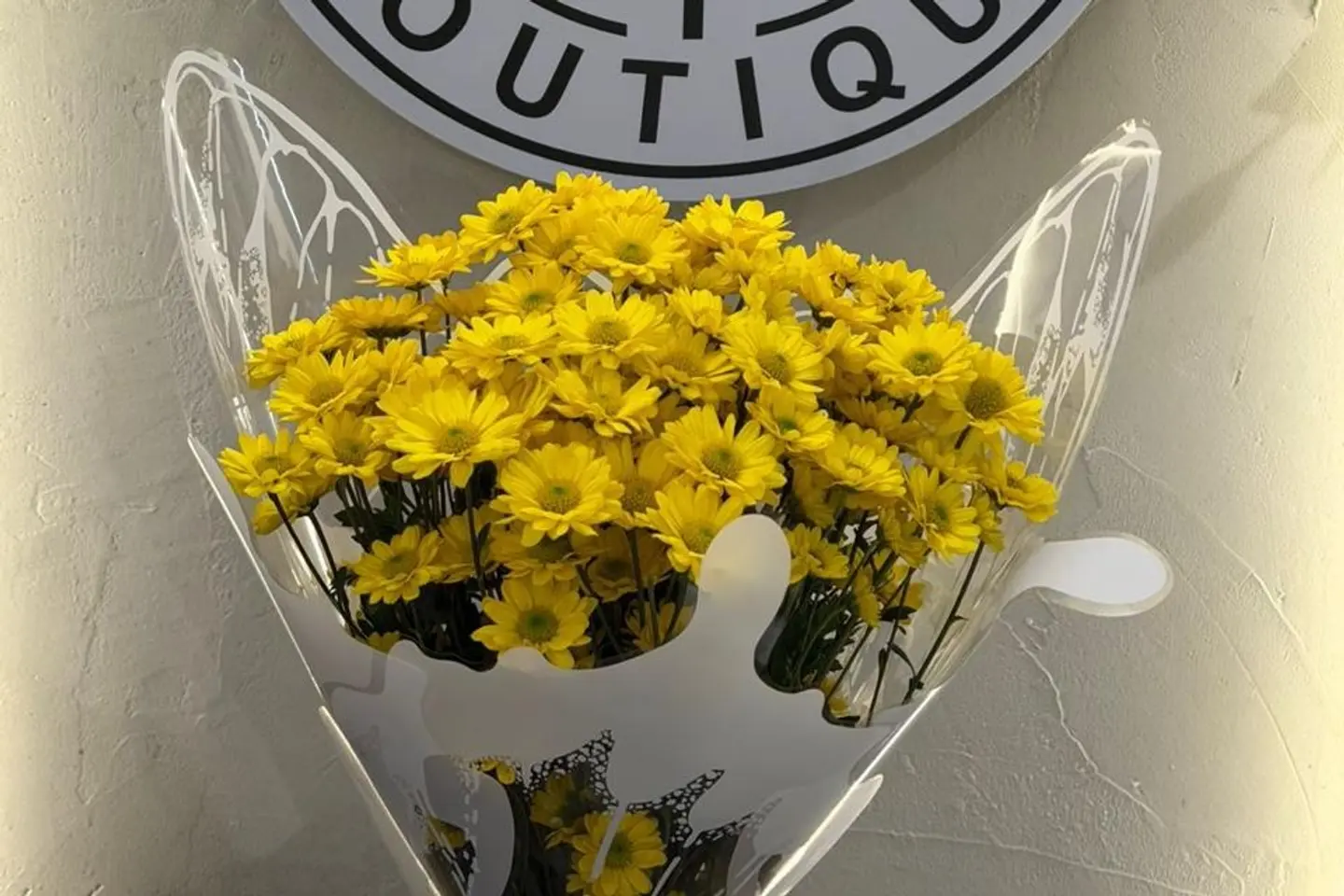 A Bouquet With Transparent Packaging And Yellow Roses