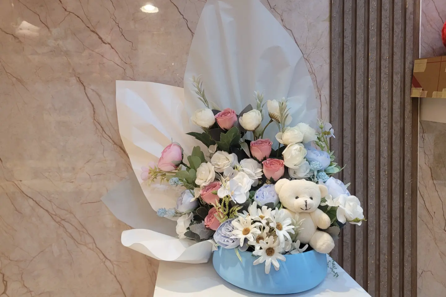 Artificial Flower Arrangement With A Teddy Bear