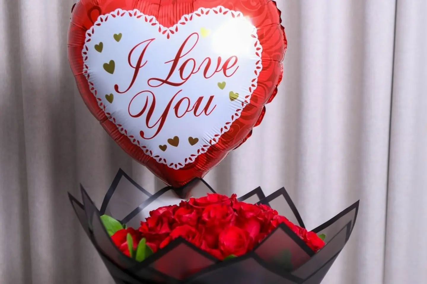 A Bouquet Of Roses With A Heart Shaped Balloon