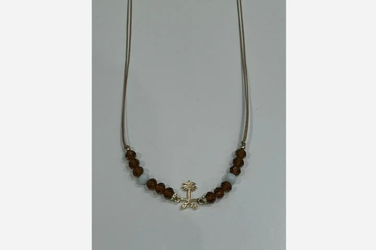 A Necklace Of Two Swords And Palm Beads