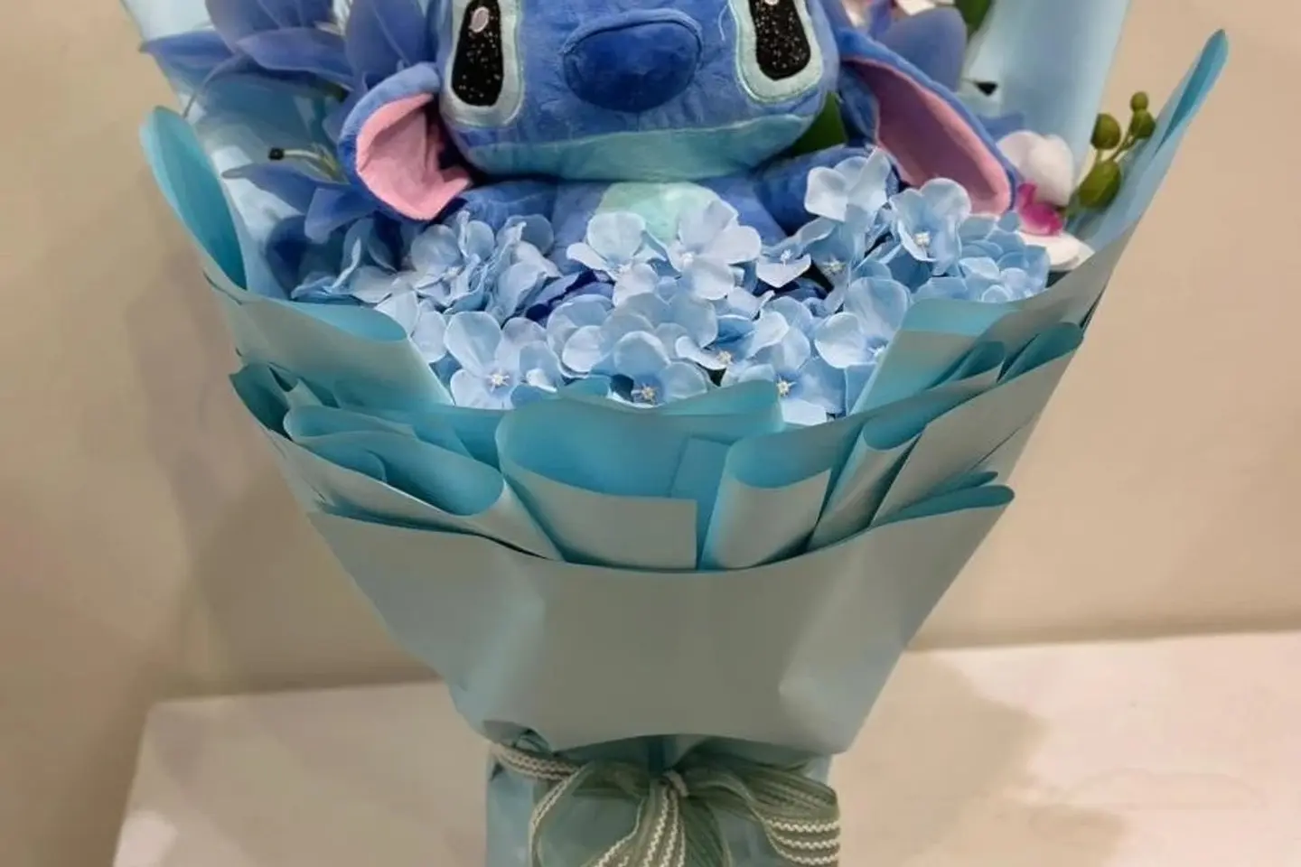 A Blue Bouquet Stitch With Artificial Flower Arrangement