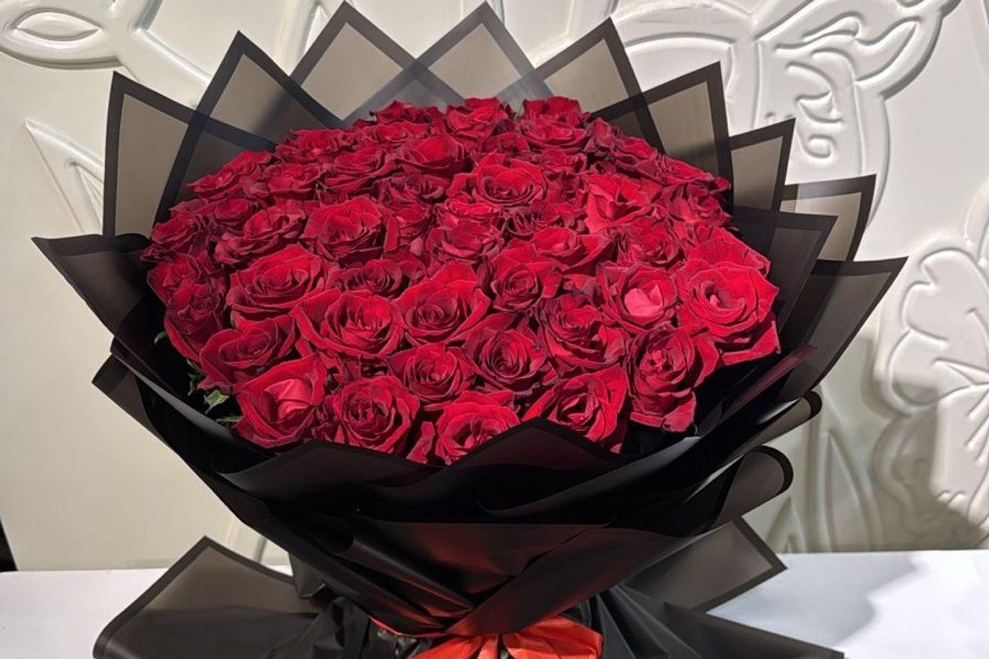 باقة جوري احمر بتغليف اسود حجم وسط