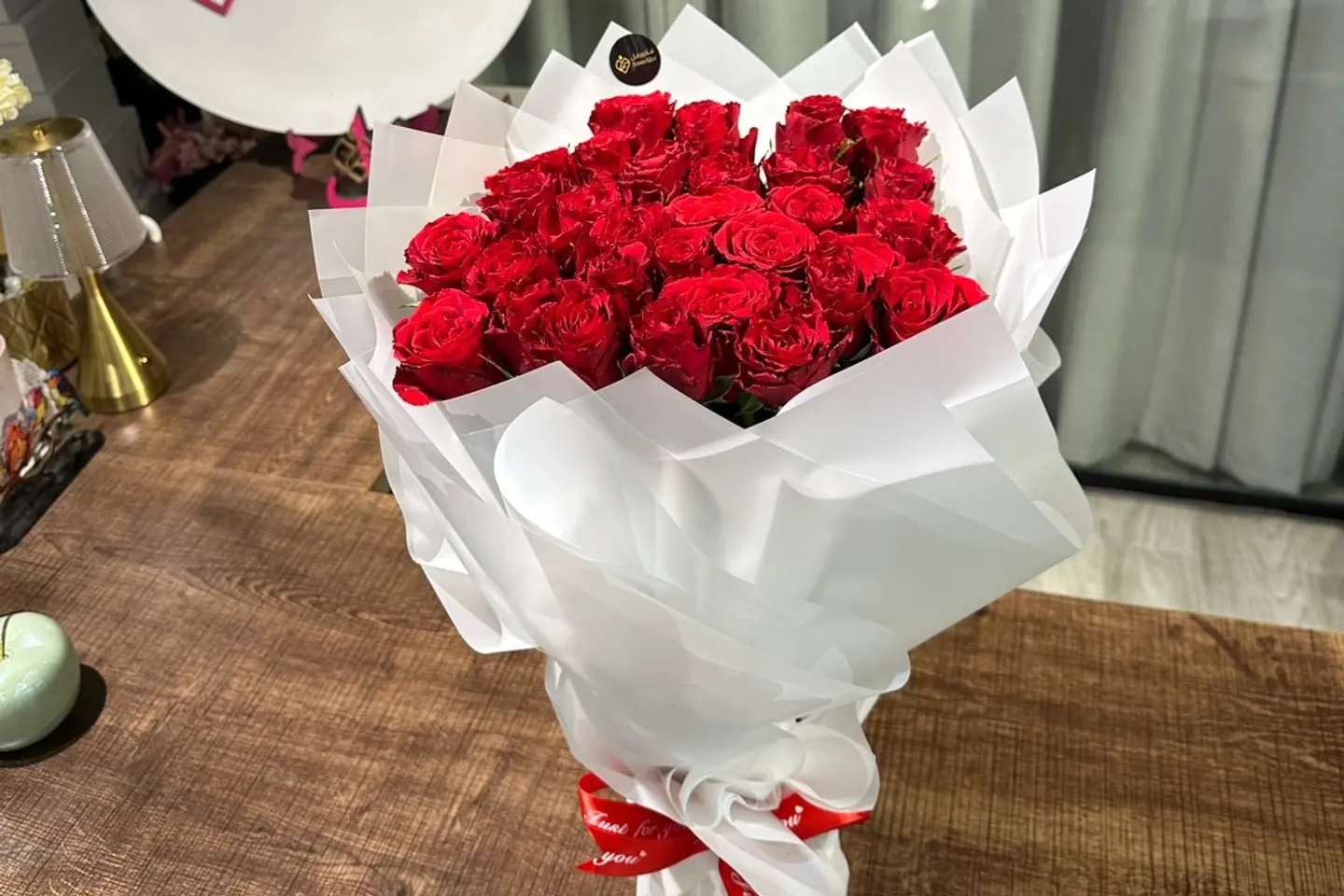 A Bouquet Of Red Roses With White Wrapping