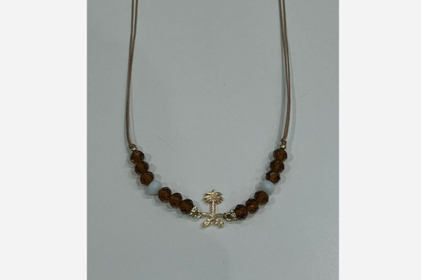 A Necklace Of Two Swords And Palm Beads