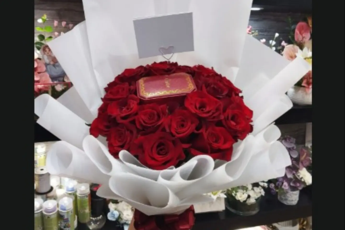 A Cartier Necklace Amidst A Bouquet Of Red Roses