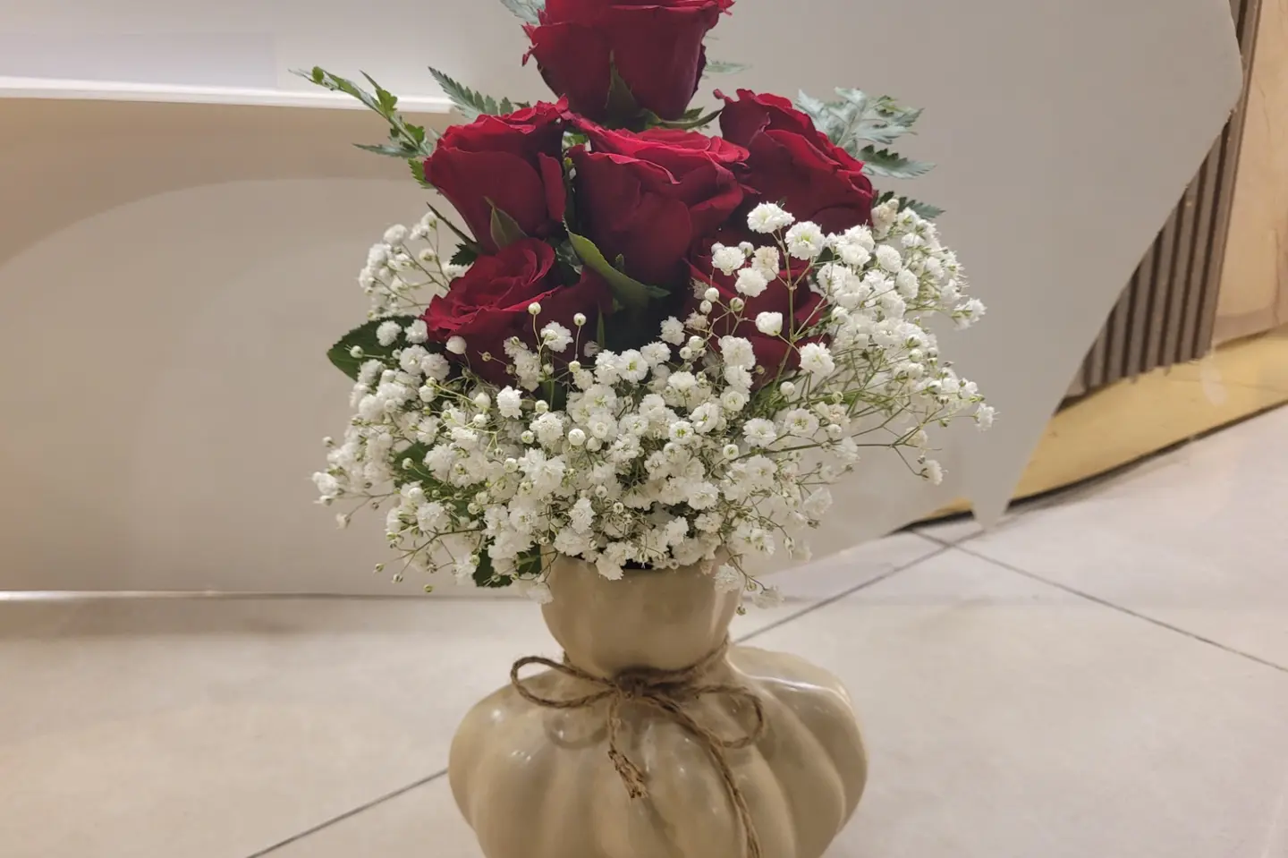 A Vase Of Red Roses With Buds