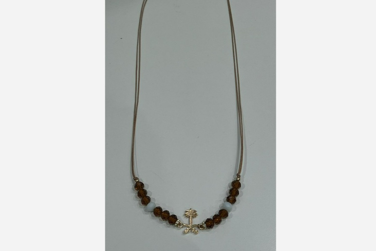 A Necklace Of Two Swords And Palm Beads