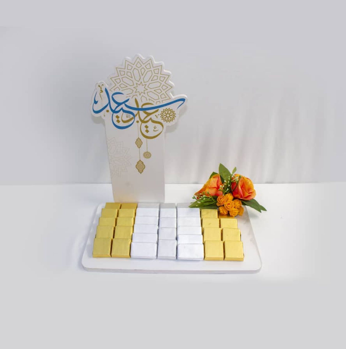 A Chocolate Tray With An Envelope And A Cork Stand Added With Eid Slogans