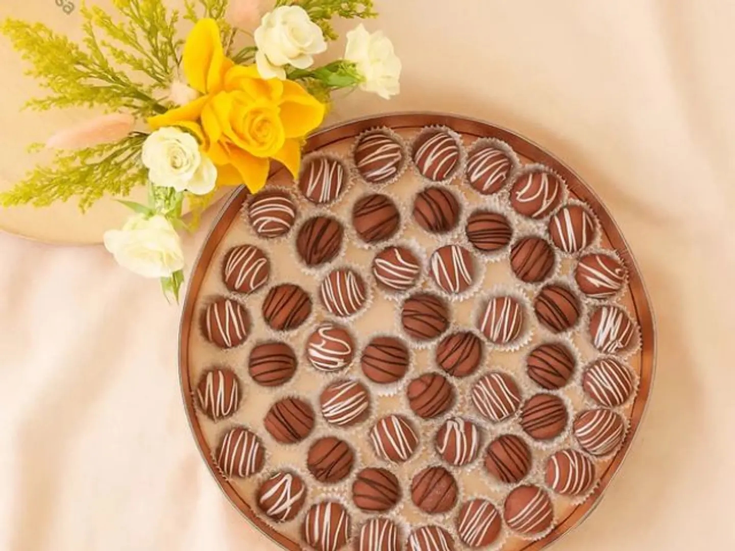 A Bouquet Of Roses And A Tray Of Chocolate Truffles