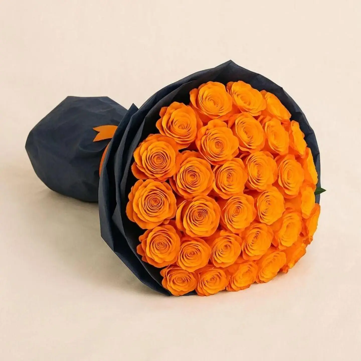 A Bouquet Of Orange Roses In A Black Wrapper