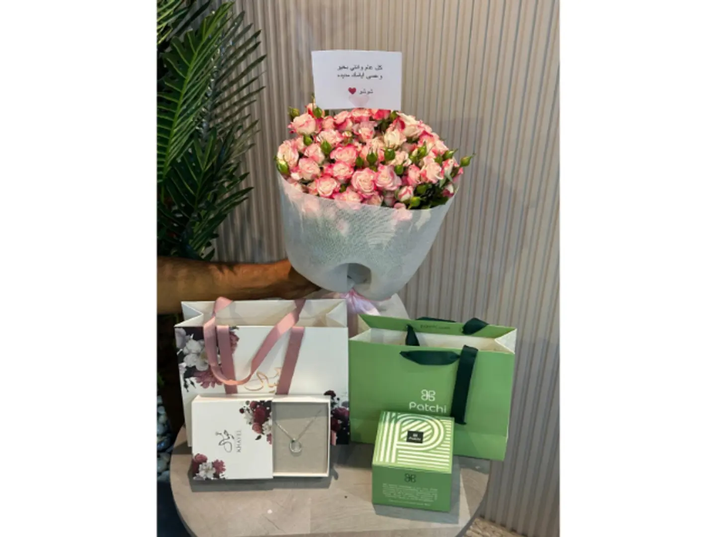 A Bouquet Of Roses With A Dream Necklace And Patchi Sweets