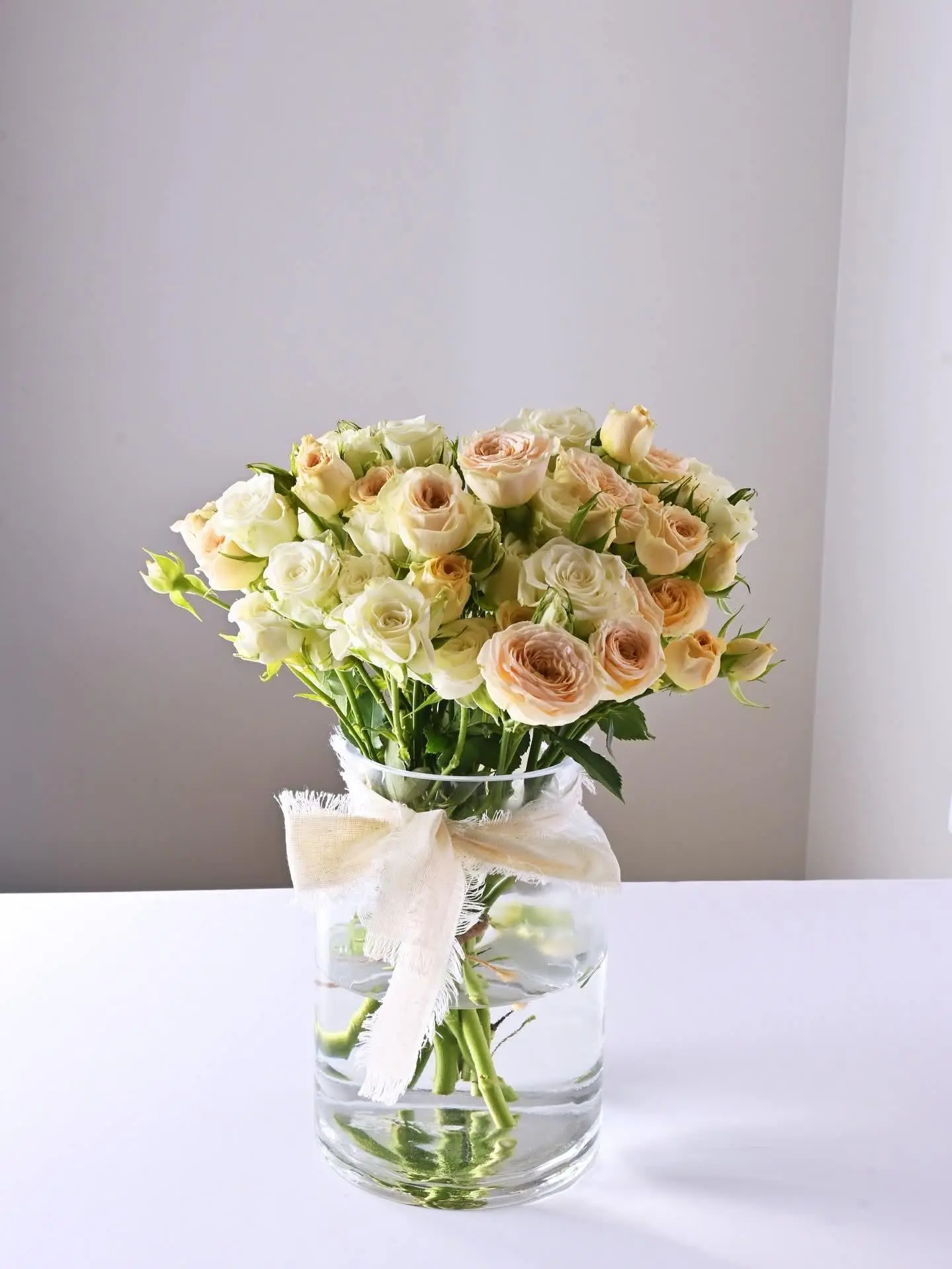 Vase With Cream Flowers And White Ribbon