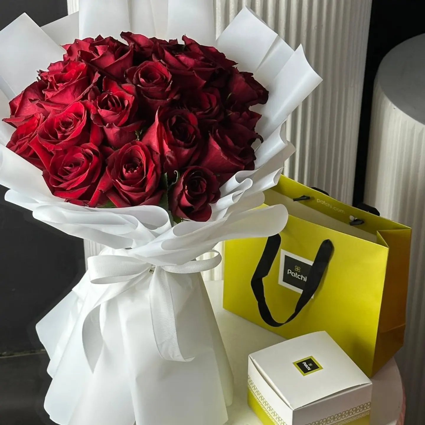 A Bouquet Of Red Roses White Wrapping With A Quarter Of Patchi