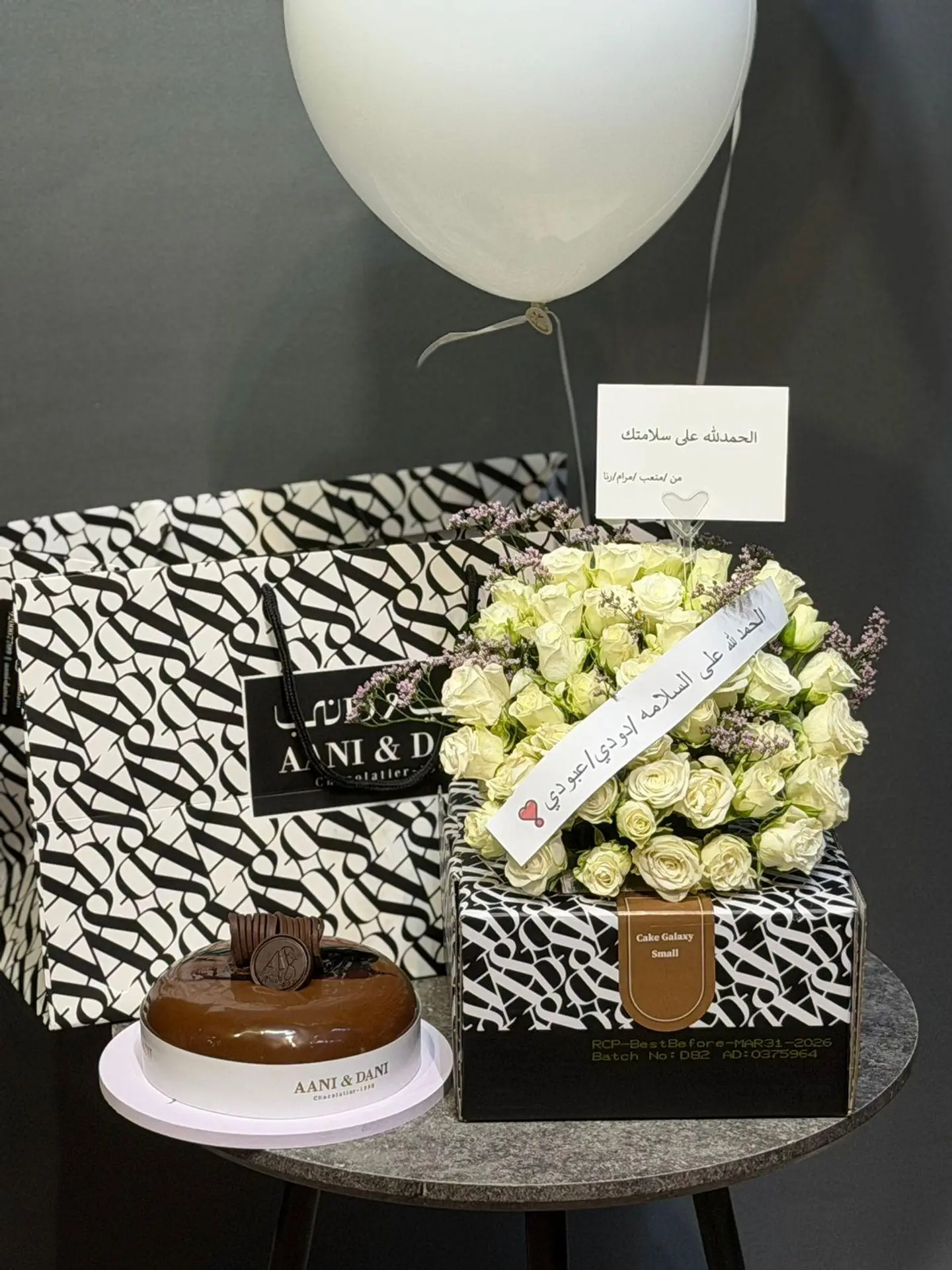 A Package Of Roses, Cake, And Balloons