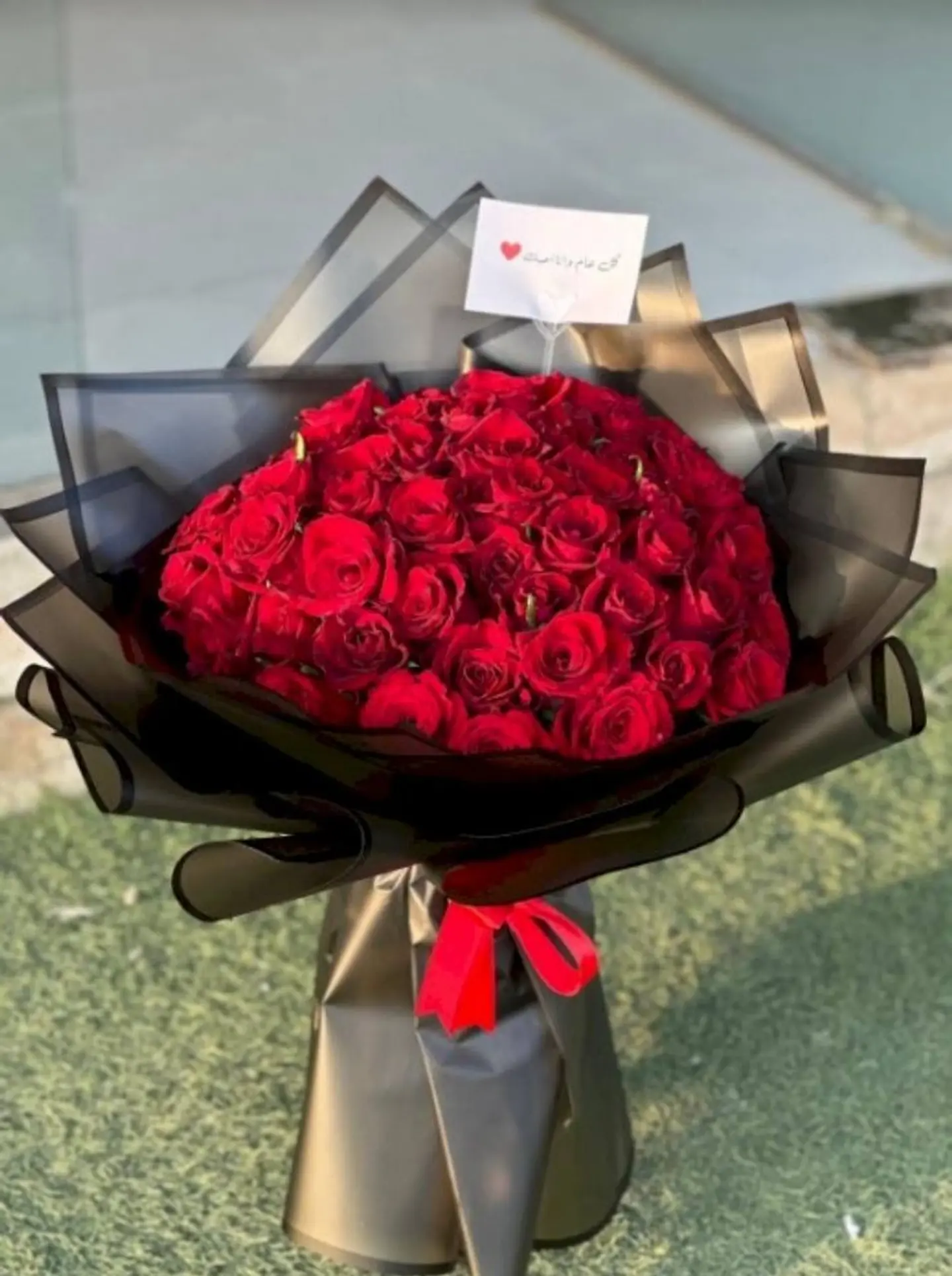 A Bouquet Of Roses In Transparent Black Packaging