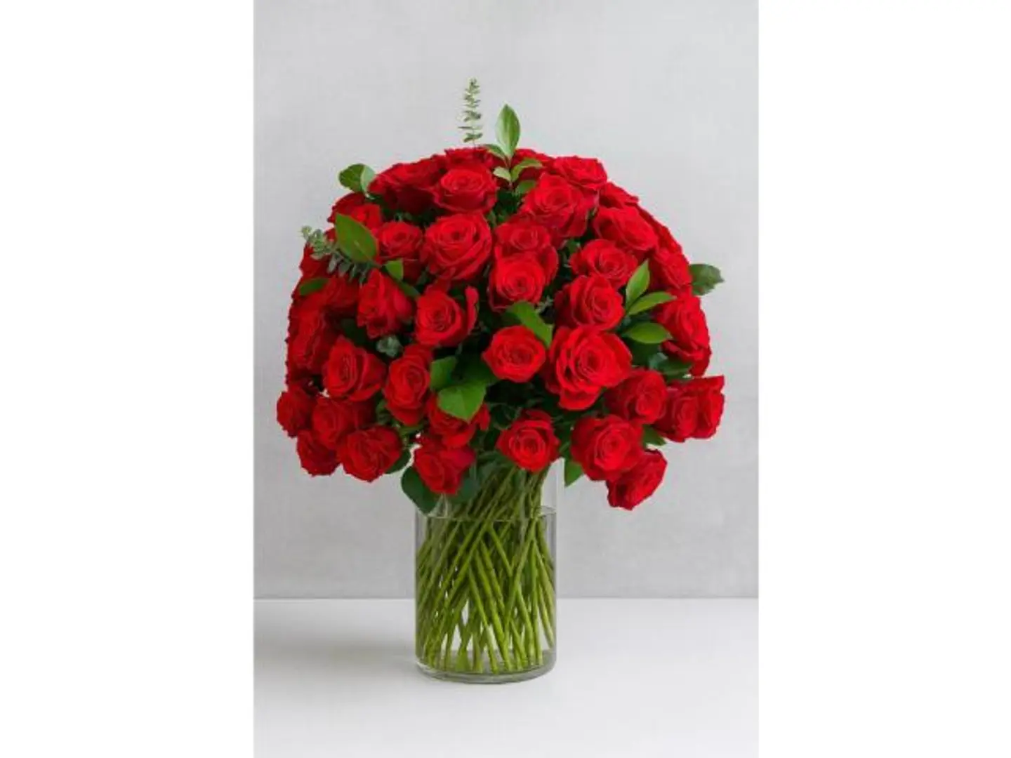 باقة 100 وردة حمراء مع تنسيق في إناء.