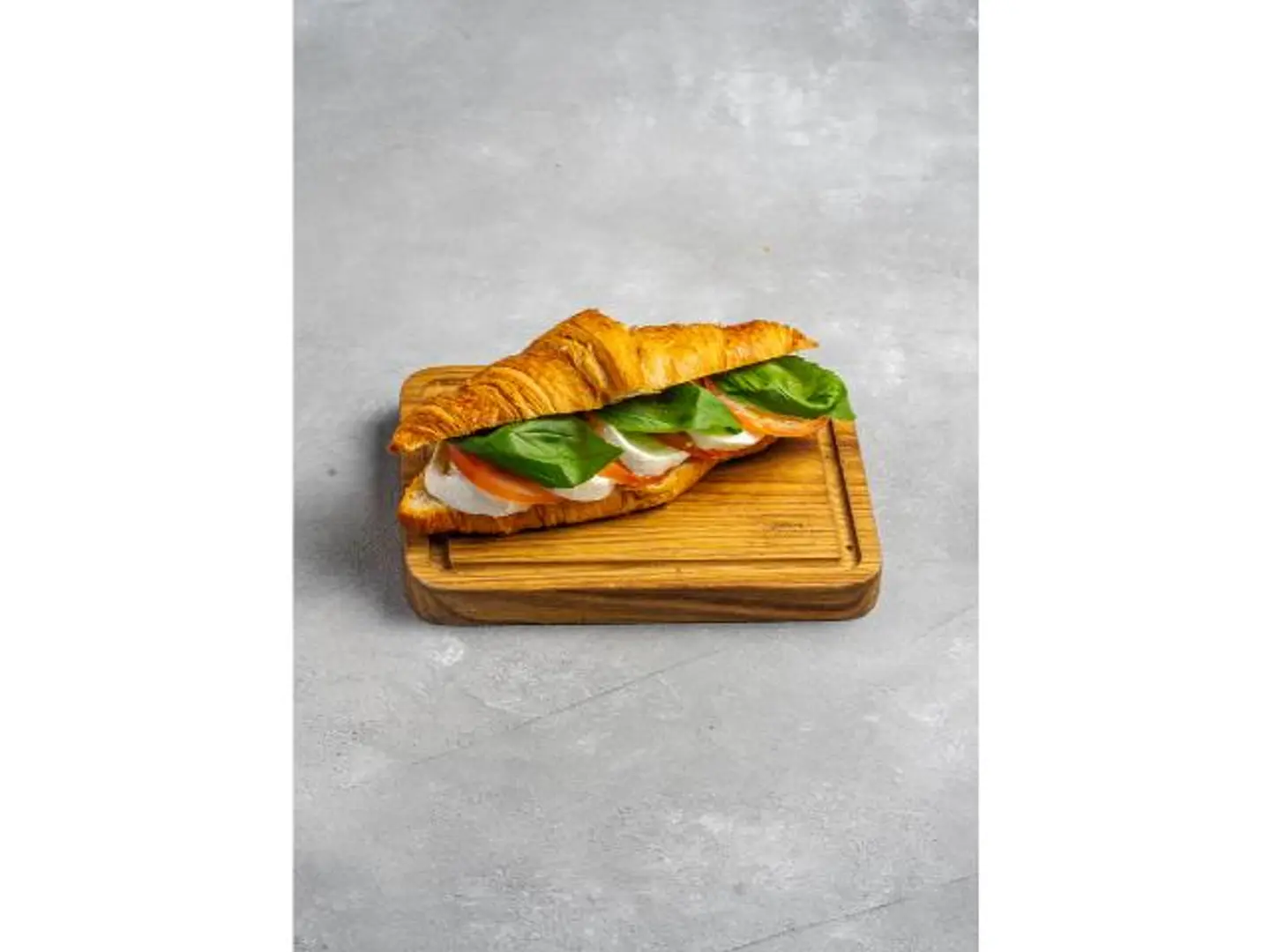 كرواسون محش موزاريلا طازجة، شرائح طماطم، وأوراق ريحان