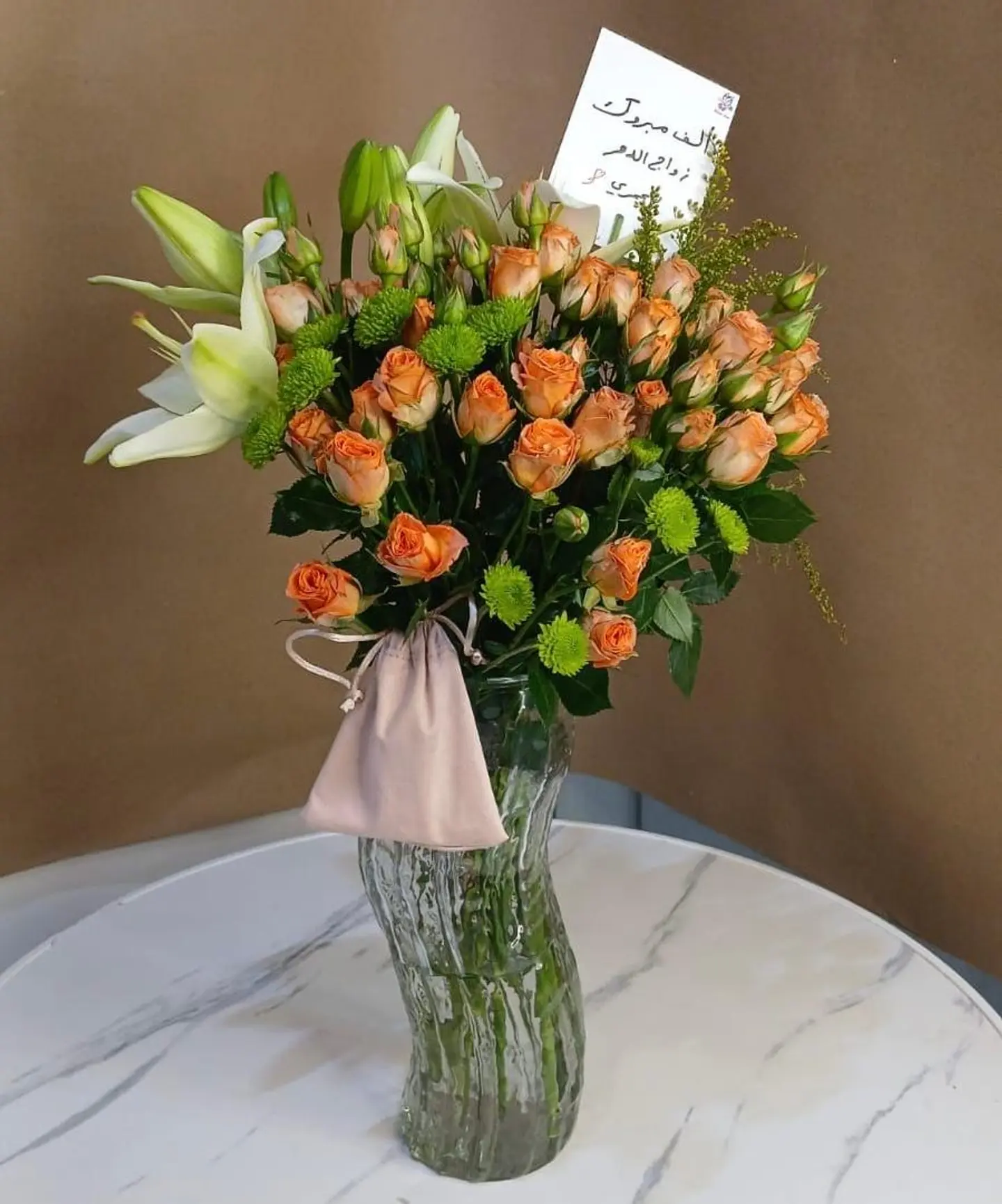 توليفة الورود البرتقالية في إناء زجاجي فريد