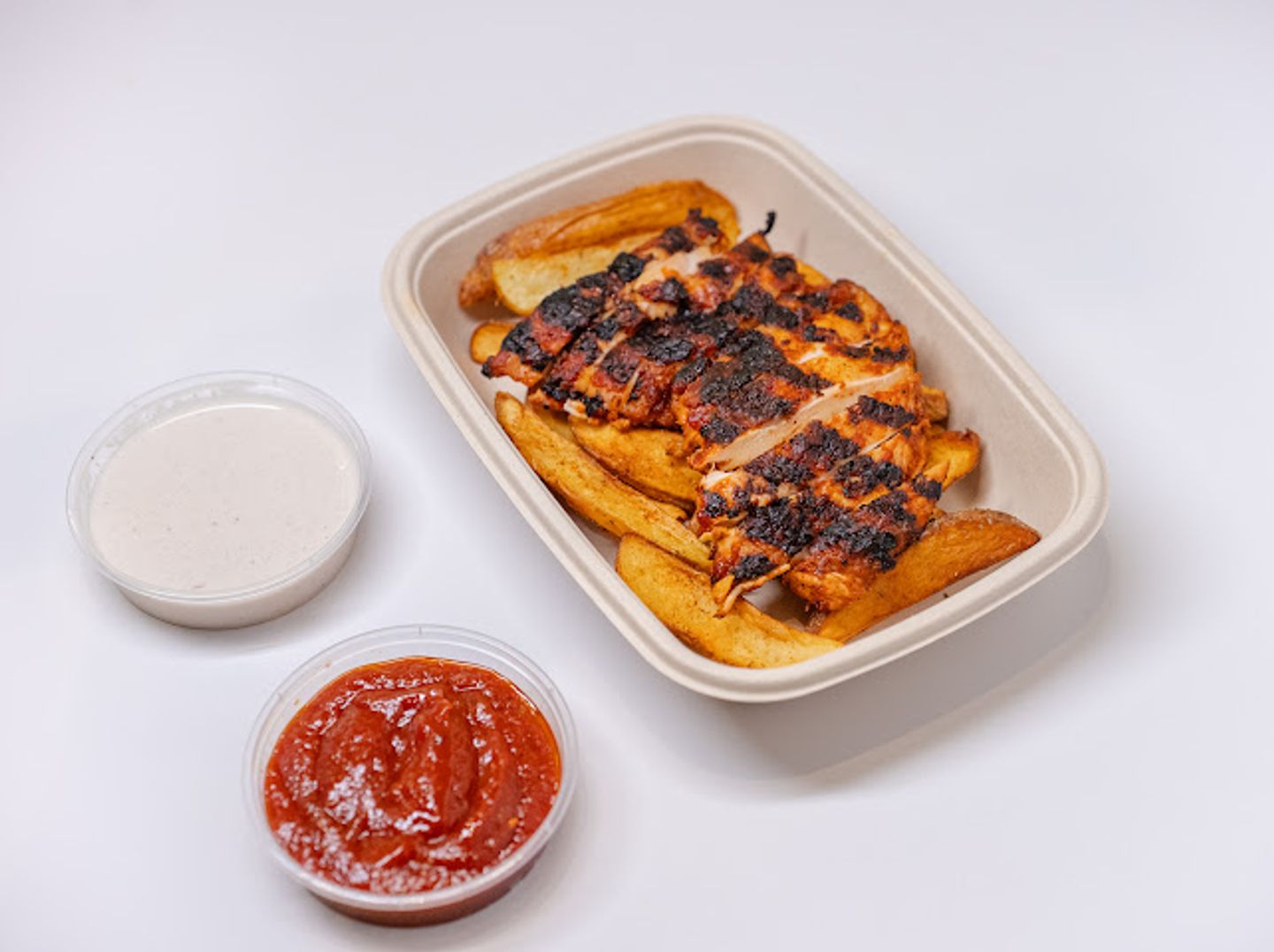 Half A Pulled Chicken Grilled On Charcoal With Potatoes