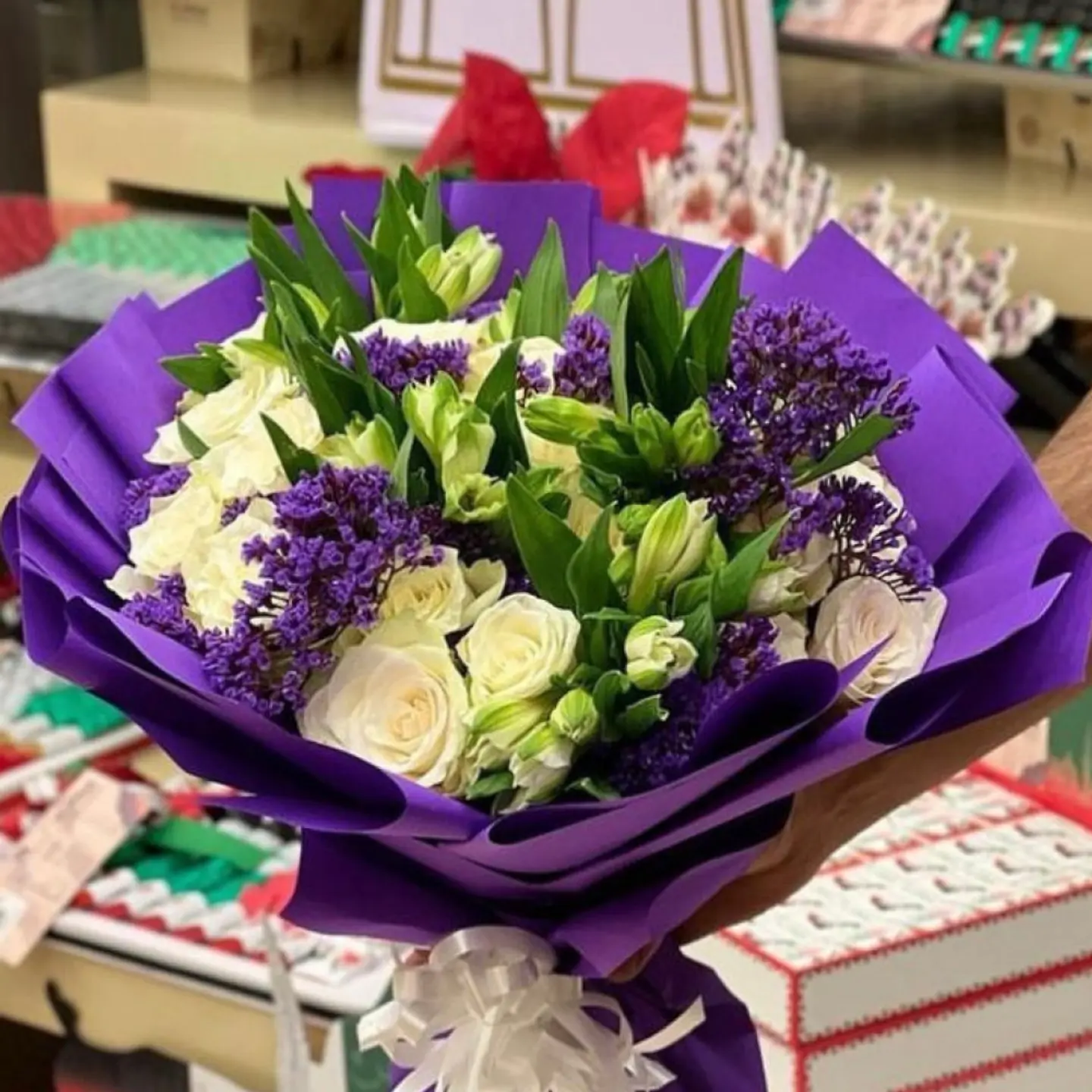 A White Rose Bouquet With A Distinctive Purple Wrapping