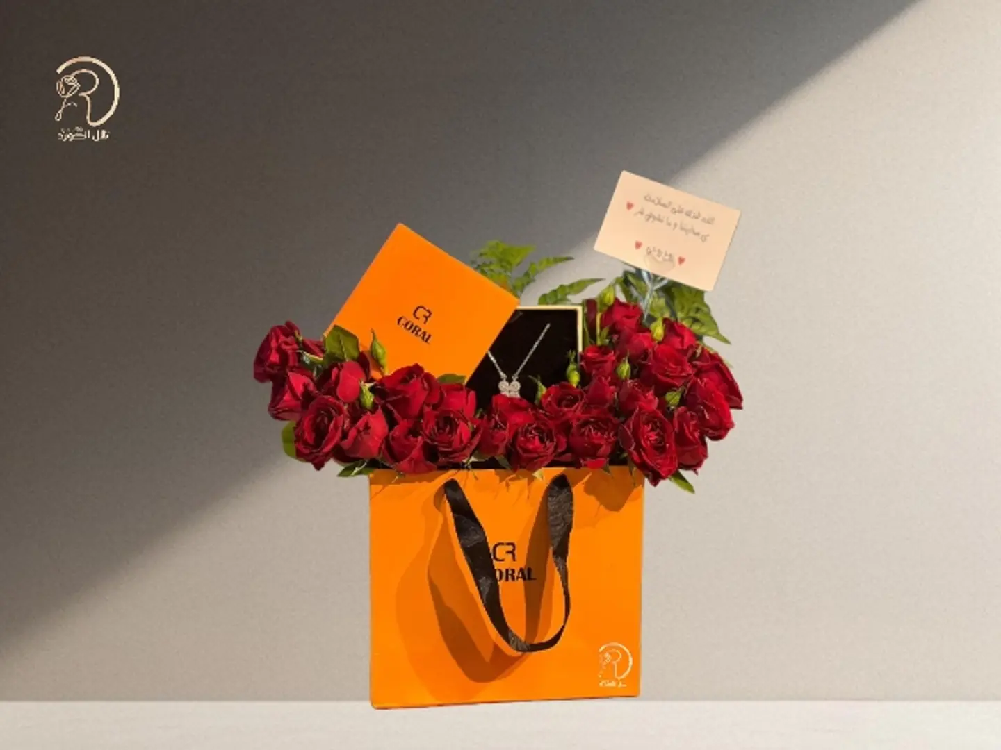 An Arrangement Of Aura Of Beauty Roses And A Coral Necklace