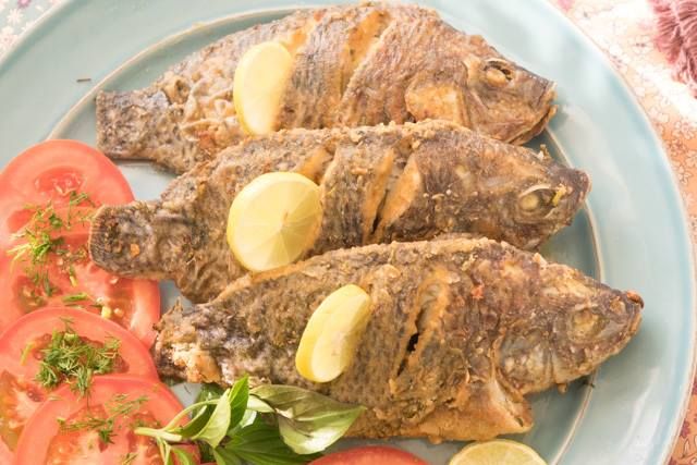Fried Tilapia Fish With Salad And Bread And Lemon
